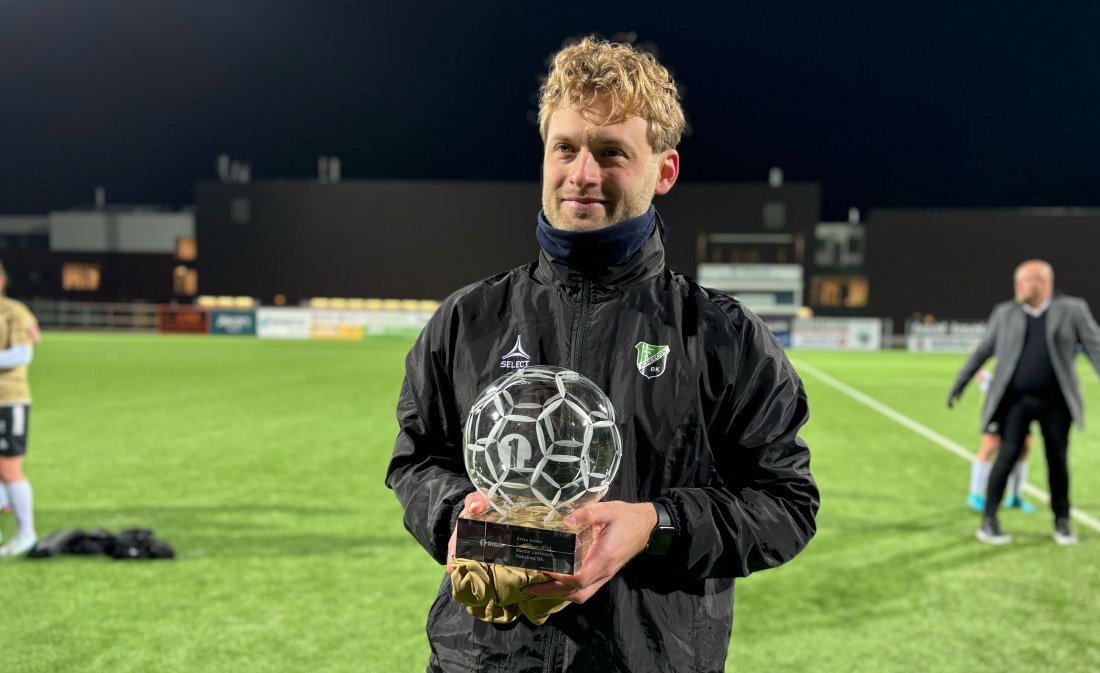 Hønefoss-trener Martin Lindmark viser frem Årets trener-troféet på AKA Arena.